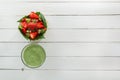 Fruit salad of strawberries, kiwi and pomegranate in a wicker basket and fresh green smoothies with lime and mint in a glass