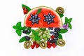 Fruit salad with watermelon, blueberry, raspberry, sweet cherry on wooden white background.