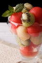 Fruit salad of watermelon, melons and kiwi in a glass close up v