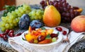 Fruit salad in white plate. Snack of fresh peaches, grapes, dogwood, plums, and mint leaves. Healthy Breakfast Royalty Free Stock Photo
