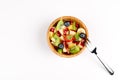 Fruit Salad in Wooden Bowl with a Fork on White Table, Top View Royalty Free Stock Photo