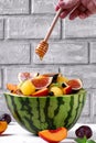 Fruit salad with yellow watermelon, fig, nectarine, plum, bilberry, apple, and banana in the watermelon half Royalty Free Stock Photo