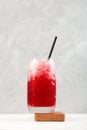 Fruit shaved ice in tall glass. Slushie - drink on grey background. Spanish granizado. Refreshing summer iced drink