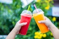 Fruit Smoothie. Hand holding plastic cup of colourful fruit smoothie at cute cafe. Hand holding plastic cup with delicious smoothi Royalty Free Stock Photo