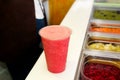 Fruit smoothie ready for sales in plastic cup with straw. Take away drinks concept. Fresh fruits juices at the public market. Royalty Free Stock Photo