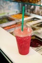 Fruit smoothie ready for sales in plastic cup with straw. Take away drinks concept. Fresh fruits juices at the public market. Royalty Free Stock Photo