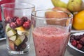 Fruit smoothies with blueberries, raspberries, apple, orange , pear and banana on gray background.