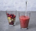 Fruit smoothies with blueberries, raspberries, apple, orange , pear and banana on gray background.