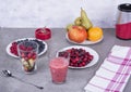 Fruit smoothies with blueberries, raspberries, apple, orange , pear and banana on gray background.