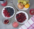 Fruit smoothies with blueberries, raspberries, apple, orange , pear and banana on gray background.