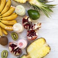 Fruit smoothies of different tastes in glass bottles with ingredients on white wooden surface. Flat lay. From above. Close-up Royalty Free Stock Photo