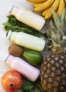 Fruit smoothies of different tastes in glass jars with ingredients on white wooden background. Top view, from above. Flat lay. Royalty Free Stock Photo