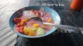 Fruit soup in a bowl consisting of sliced ??jackfruit, melon, guava, pineapple, watermelon and a mixture of milk and syrup.