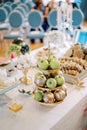 Fruit stand sits on a table near a jar of honey and colorful treats Royalty Free Stock Photo