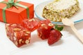 Fruit sweets with nuts and gift box on white background.