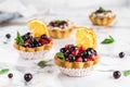 Fruit tart with orange, pomegranate, currant and cream, cakes and sweetness on light marble background. Delicious dessert