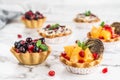 Fruit tart with orange, pomegranate, currant and cream, cakes and sweetness on light marble background. Delicious dessert