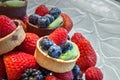 Fruit tarts on top of mixed berry background that includes red strawberries Royalty Free Stock Photo