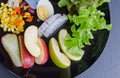 Fruit and vegetable salad on black plate Royalty Free Stock Photo