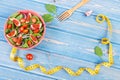 Fruit and vegetable salad, fork with tape measure, slimming and nutrition concept, copy space for text on boards Royalty Free Stock Photo