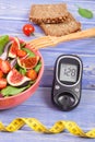 Fruit and vegetable salad and glucometer for checking sugar level with tape measure, concept of diabetes Royalty Free Stock Photo