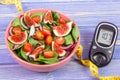 Fruit and vegetable salad and glucose meter with tape measure, concept of diabetes, slimming and healthy nutrition Royalty Free Stock Photo