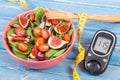 Fruit and vegetable salad and glucometer with tape measure, concept of diabetes, slimming and healthy nutrition Royalty Free Stock Photo