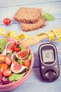 Fruit and vegetable salad and glucometer with tape measure, concept of diabetes, slimming and healthy nutrition Royalty Free Stock Photo