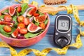 Fruit and vegetable salad and glucometer with tape measure, concept of diabetes, slimming and healthy nutrition Royalty Free Stock Photo