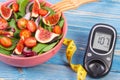 Fruit and vegetable salad and glucose meter with tape measure, concept of diabetes, slimming and healthy nutrition Royalty Free Stock Photo