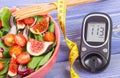 Fruit and vegetable salad and glucose meter with tape measure, concept of diabetes, slimming and healthy nutrition Royalty Free Stock Photo