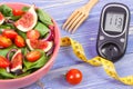 Fruit and vegetable salad and glucose meter with tape measure, concept of diabetes, slimming and healthy nutrition Royalty Free Stock Photo