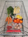 Fruit, vegetables in reusable textile fabric bags Pouch in shopping cart. Top view or flat lay. Cart with food product close up,