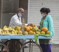 Fruit vendor on the streets of India with virus protection mask