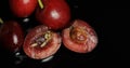 Fruit worms in rotten cherry, black background. Larva of cherry flies. Closeup