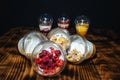 Fruit yogurts on black background. Healthy breakfast on the wooden table.