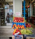 Fruiterer shop with produce displayed on street and humorous sign pleading with customers not to squeeze the fruit