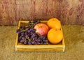 Fruits (apple, orange , grape ) in an wood box, on sack sisal Royalty Free Stock Photo