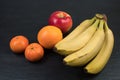 Fruits. Bananas, apples, oranges, tangerines on a black background Royalty Free Stock Photo