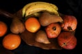 Fruits on black background. Pomegranates, oranges, pears, bananas basket Royalty Free Stock Photo