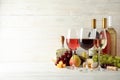 Fruits, cheese, bottles and glasses with different wine on white background