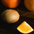 Fruits on a dark background. Close-up of oranges and kiwi on a wooden cutting board