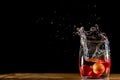 Fruits dropping into a glass of water. Flash strobes shot on a black background
