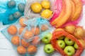 Fruits in eco-friendly shopping bags on white wooden background Royalty Free Stock Photo