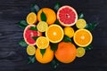 Fruits, half grapefruits, lemons, oranges, limes with green leaves lie on a brown wooden table Royalty Free Stock Photo