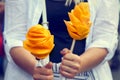 The fruits of a juicy ripe mango in the form of flowers in the hands of a young girl. Mexico street food.