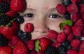 Fruits for kids. Kids face with fresh berries fruits. Assorted mix of berries strawberry, blueberry, raspberry Royalty Free Stock Photo