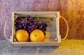 Fruits ( orange , grape ) in an wood box, on sack sisal background Royalty Free Stock Photo