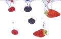 Fruits plunging into water. Strawberry, blackberry and raspberry splashing into fresh water. Royalty Free Stock Photo