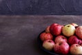 Fruits -rustic apples on a platter on a dark background